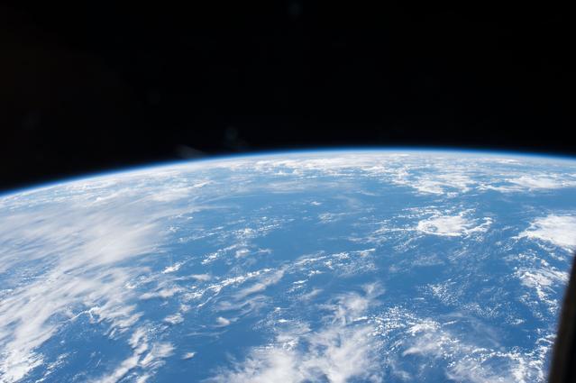 A blue and white Earth against black space taken from the International Space Station