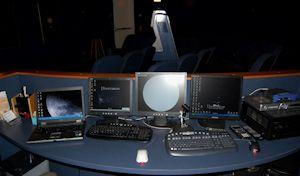 Planetariums control console, four different monitors on a desk with 3 different keyboards help run the show